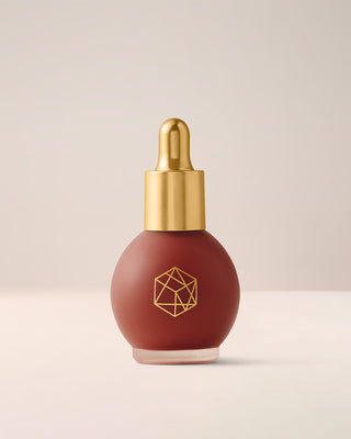 EM Cosmetics Color Drops Serum Blush in Forbidden Fruit, a vibrant poppy shade for a bold, buildable, dewy cheek color.