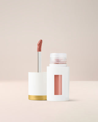 EM Cosmetics Everglass Lip Dew in Lullaby, a peachy nude gloss that provides a comfortable, mirror-like shine.