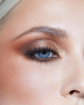 Model with light skin wearing EM Cosmetics Divine Skies Palette in Da Vinci for a soft, warm neutral eye look.