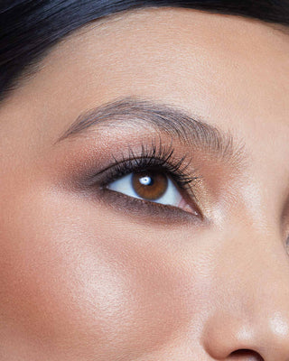 Model with medium skin wearing EM Cosmetics Divine Skies Palette in Da Vinci for a classic, warm neutral eye look.