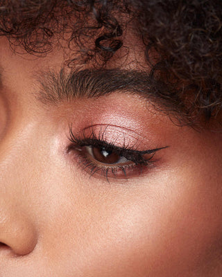 Model with dark skin wearing EM Cosmetics Divine Skies in Venetian Rose for a rich, deep rose eye look.