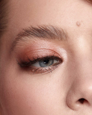 Model with light skin wearing EM Cosmetics Divine Skies in Venetian Rose for a soft, romantic pink eye look.