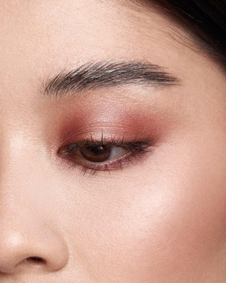 Model with medium skin wearing EM Cosmetics Divine Skies in Venetian Rose, creating a defined, rosy eye look.