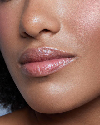 Model with dark skin wearing EM Cosmetics Lip Cushion in Mona Lisa for a glossy, hydrated chestnut lip look.