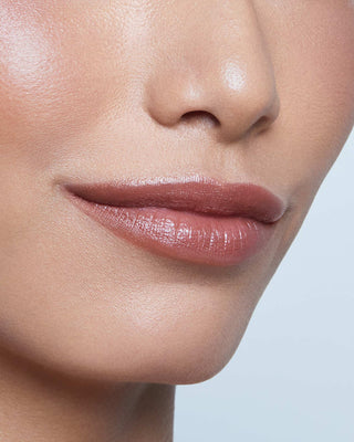 Model with medium skin wearing EM Cosmetics Lip Cushion in Van Gogh for a hydrated, tinted deep rose lip look.