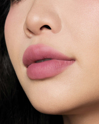 Michelle Phan wearing EM Cosmetics Phantom Blur Lip Tint in Odette, creating a soft, warm rosy mauve blurred lip.