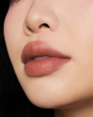 Michelle Phan wearing EM Cosmetics Phantom Blur Lip Tint in Sahar, creating a soft, warm rosy nude blurred lip.