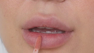 Model with medium skin wearing EM Cosmetics Everglass Lip Dew in Dream for a glossy, high-shine clear lip look.