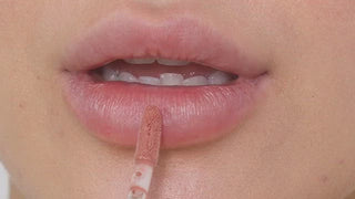 Model with light skin wearing EM Cosmetics Everglass Lip Dew in Lullaby for a glossy, soft rose lip look.