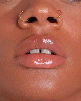 EM Cosmetics Everglass Lip Dew in Lullaby, a soft nude rose shade, shown in its sleek, minimalist packaging.
