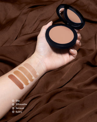 Arm swatches of EM Cosmetics Corselette Sculpting Bronzer in Slip, showing the soft, matte powder texture.