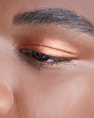 Male model wearing EM Cosmetics Cosmic Pearl Eyeshadow in Helios, enhancing the eyes with a metallic copper glow.
