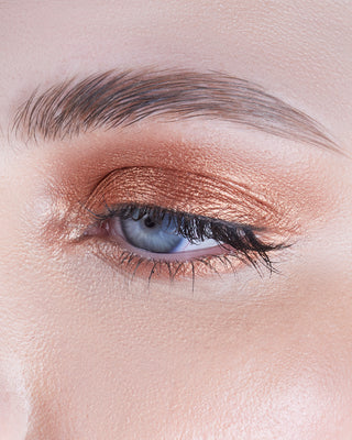 Model wearing EM Cosmetics Cosmic Pearl Eyeshadow in Helios, a metallic copper shade, for a radiant gaze.