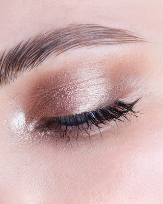 Model wearing EM Cosmetics Cosmic Pearl Eyeshadow in Moonrise, a rosy champagne shade, for a radiant gaze.
