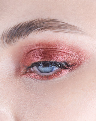 Model with light skin wearing EM Cosmetics Cosmic Pearl Eyeshadow in Scorpius for a smoky, metallic bronze eye look.