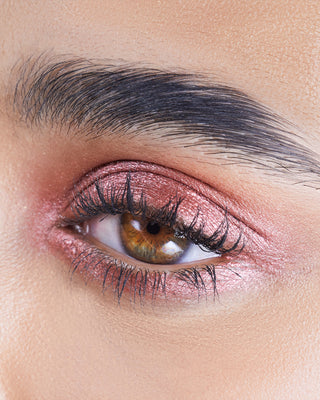 Model with medium skin wearing EM Cosmetics Cosmic Pearl Eyeshadow in Starchild for a soft, metallic champagne eye.