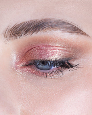 Model wearing EM Cosmetics Cosmic Pearl Eyeshadow in Venus, a sparkling rose shade, for a radiant gaze.