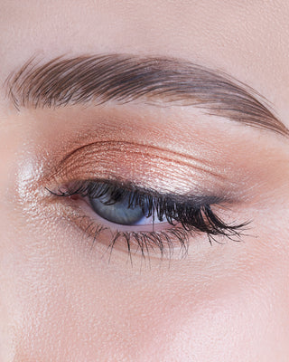 Model wearing EM Cosmetics Cosmic Pearl Eyeshadow in Wish, a warm beige shade, for a radiant gaze.