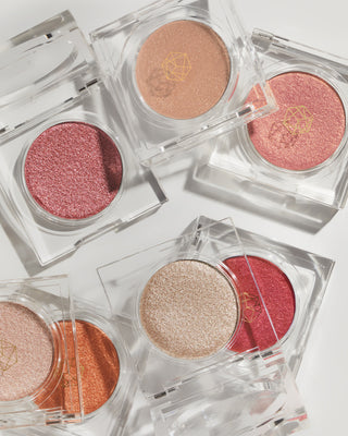 Open compact of EM Cosmetics Cosmic Pearl Eyeshadow in Luna, showing the golden champagne pressed powder.