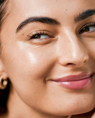 Beauty shot showcasing the subtle, radiant finish of EM Cosmetics Face Cuddle Moisture Balm on a model's high points.