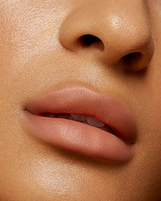 Model Kyrah wearing EM Cosmetics Soft Blur Velvet Lip Liner in Fawn for soft lip contouring.