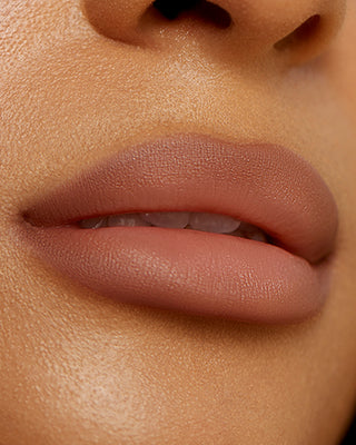 Model Kyrah wearing EM Cosmetics Soft Blur Velvet Lip Liner in Mink for a soft contour.