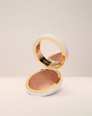 EM Cosmetics Sunscape Highlighter in Legendary, a golden pearl shade, shown in its open compact.